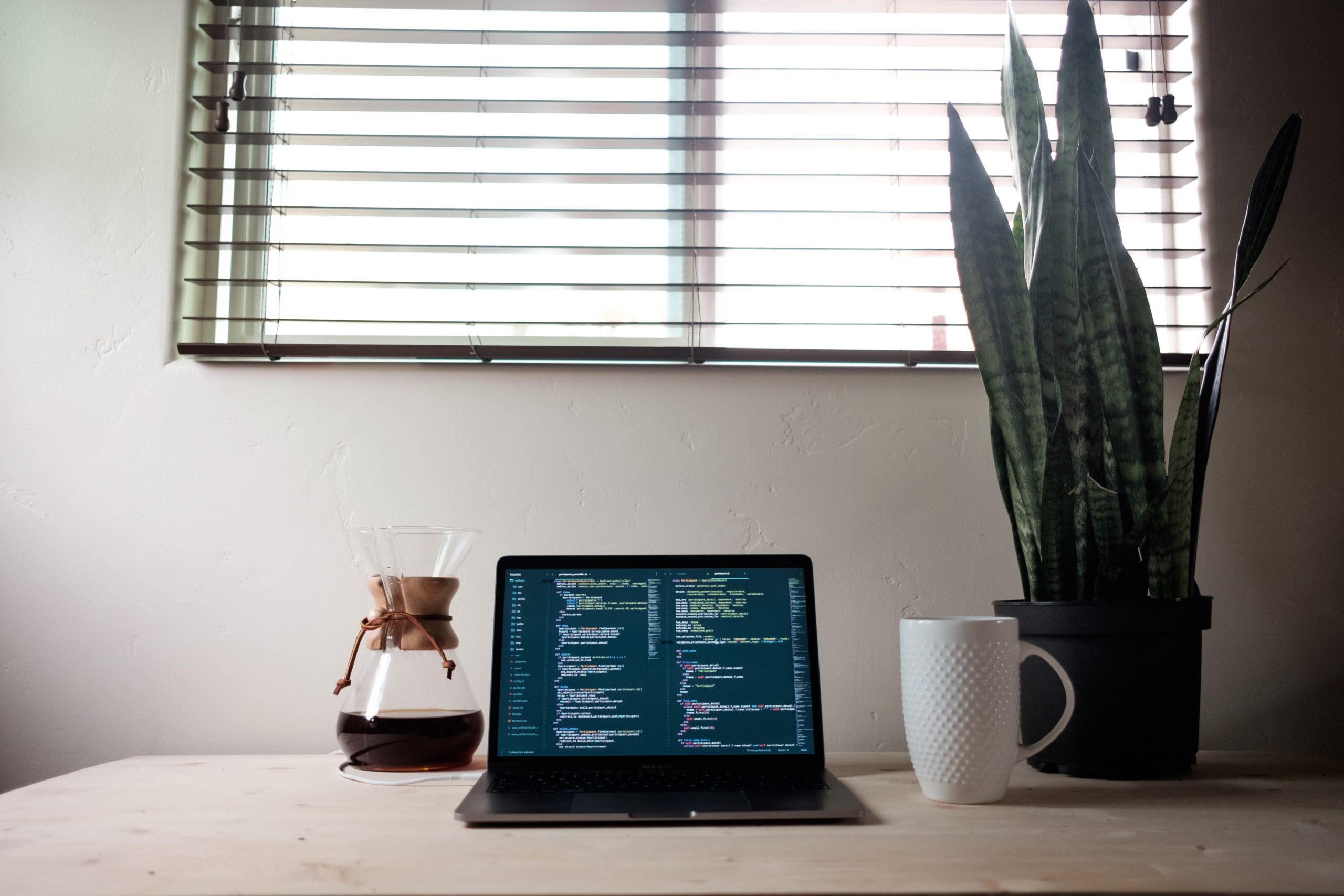 Photo of Laptop and Coffee on a desk in front of a window