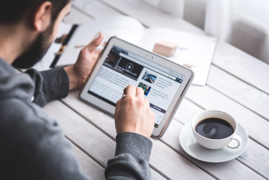 Photo of man reading news on a table computer