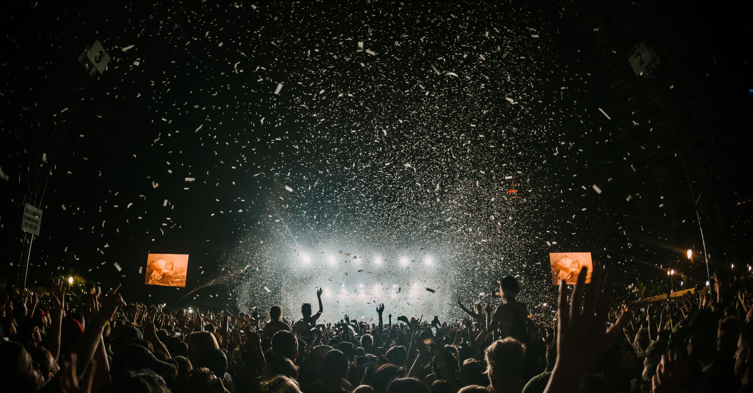 A crowd at a concert with confetti falling from above