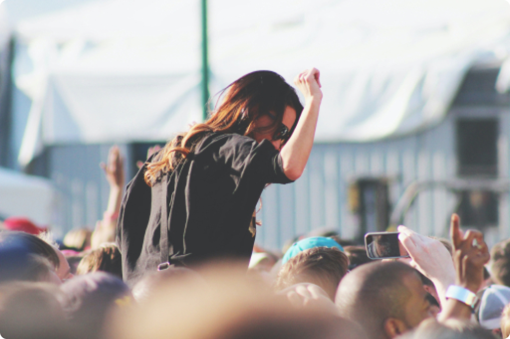 woman dancing on someones shoulders in festival crowd